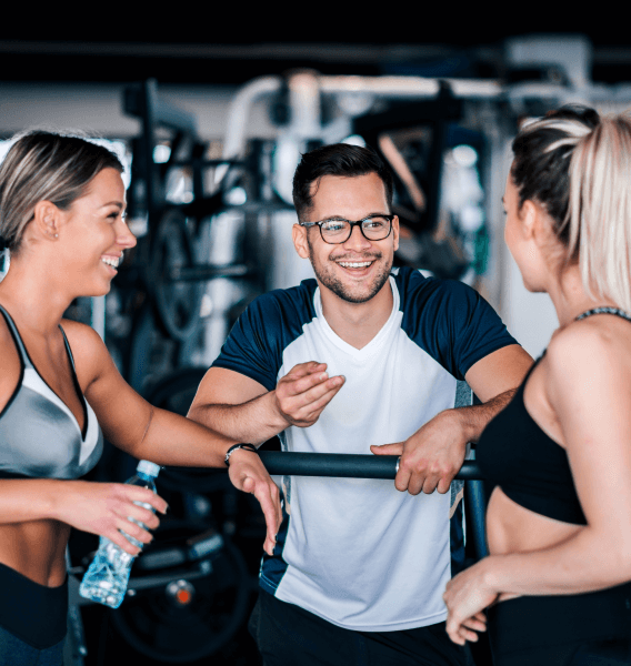 Man and two women talking in a gym